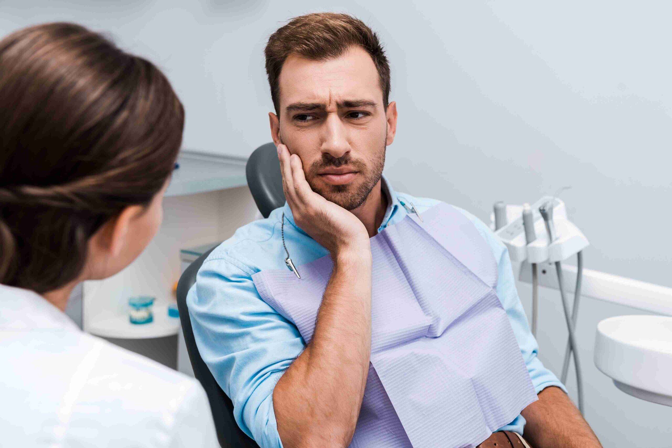 Patient discussing tooth pain with a dentist.