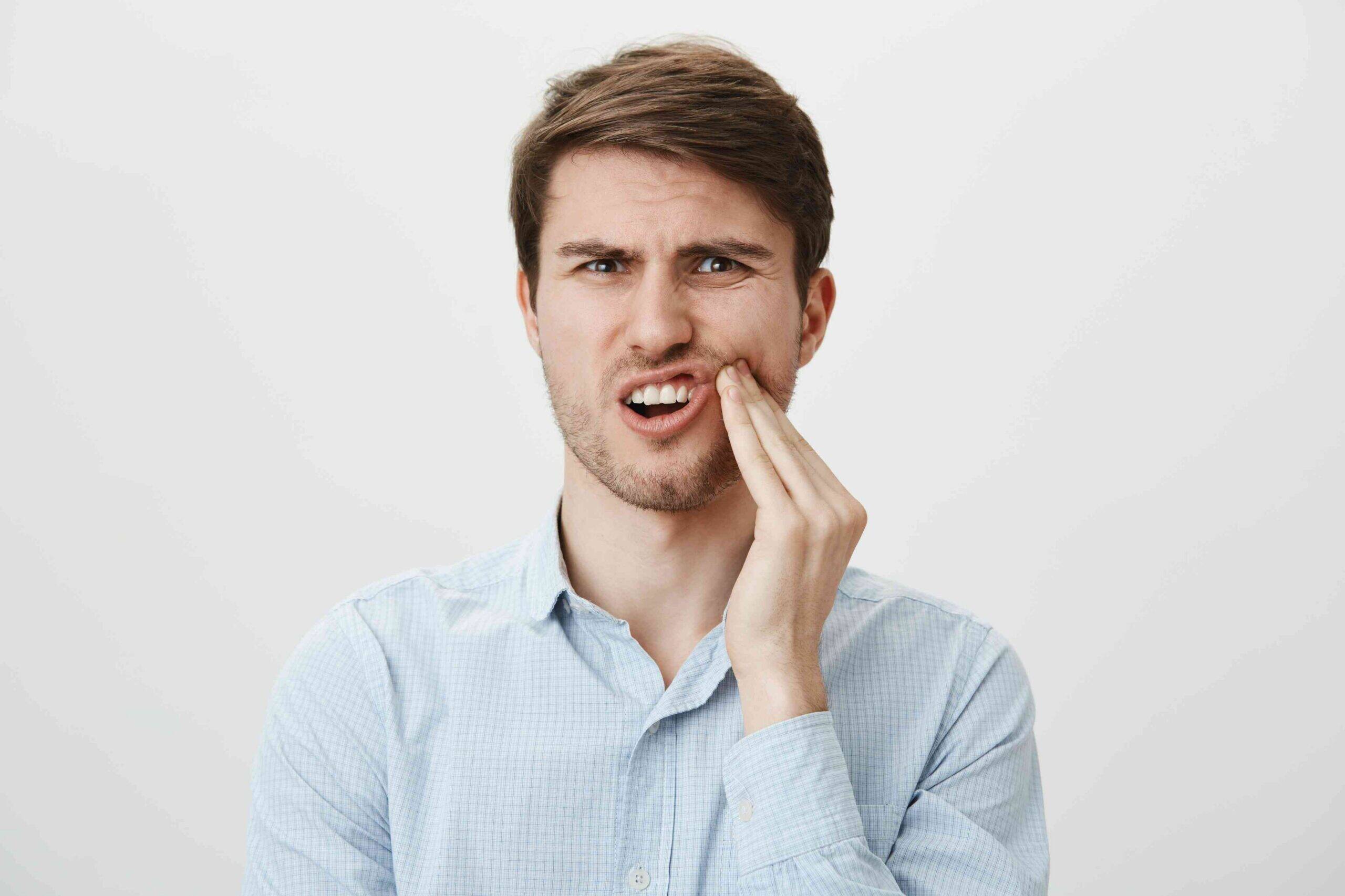 Man holding his jaw in pain.