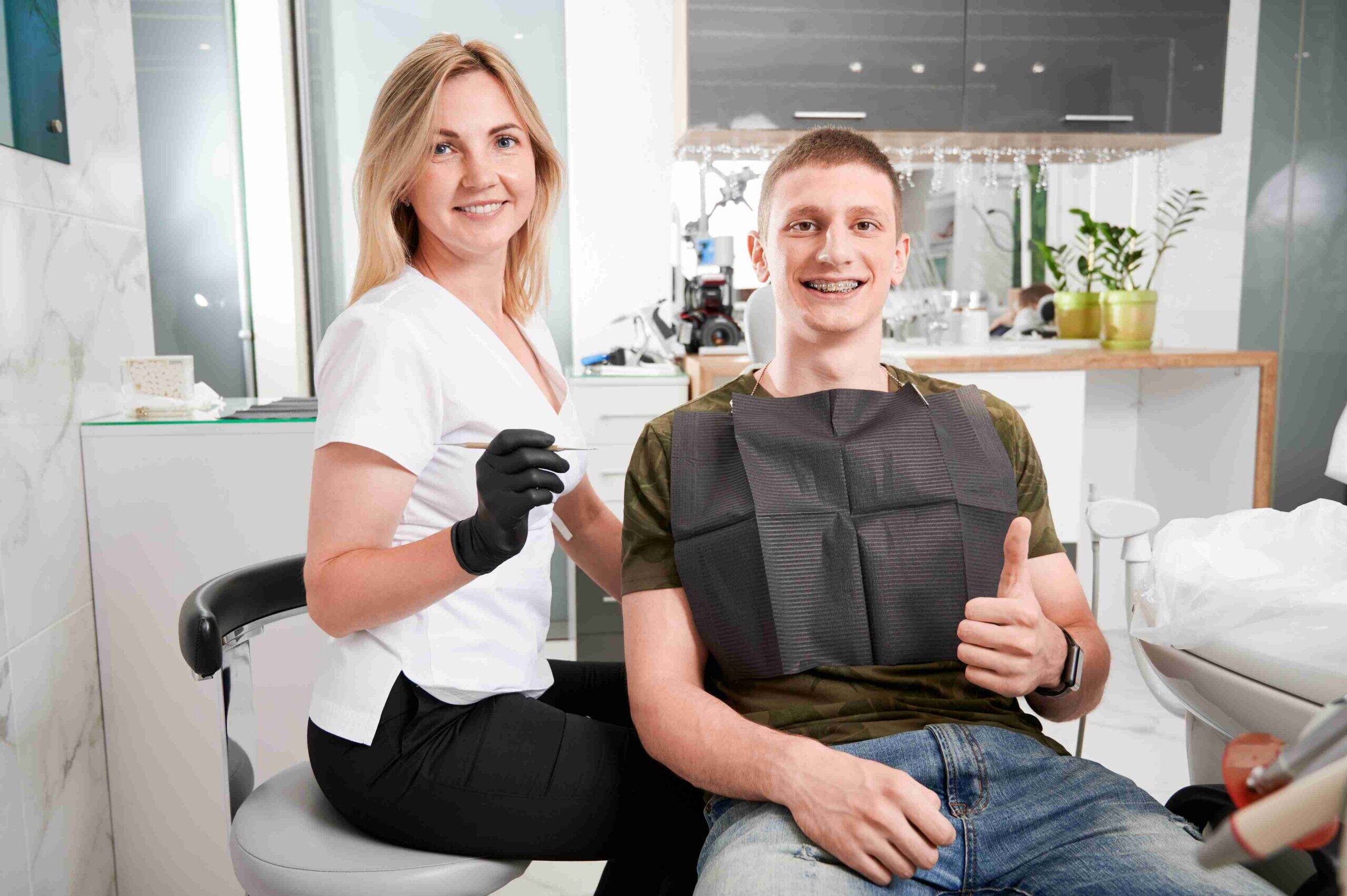 Smiling patient with dentist after braces treatment.